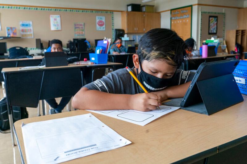 Student wearing a mask at his desk.
