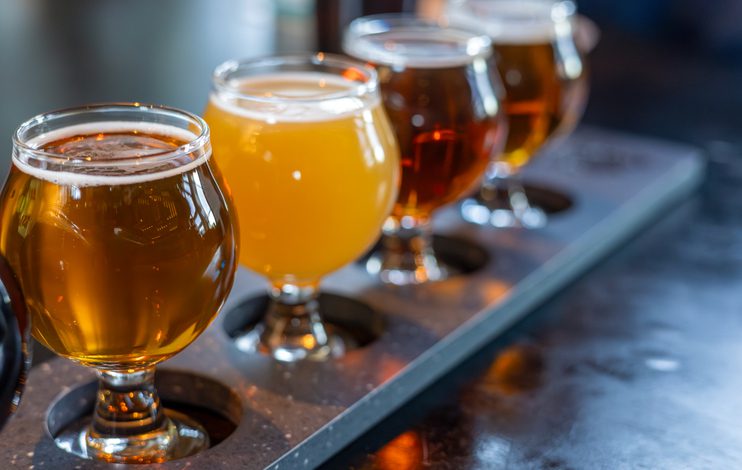 Craft beers served together in a sampler tray for the beer enthusiast in a brewery. Selective focus.