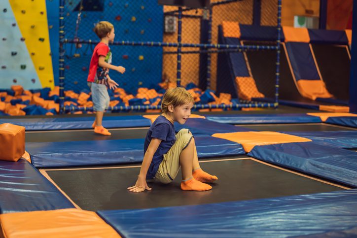 Cute boy jumping on trampoline in trampoline park.