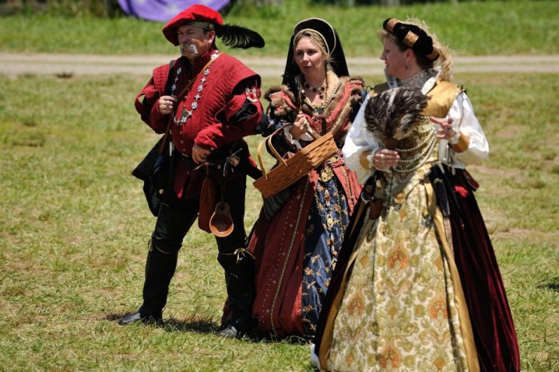 three ren faire actors clad in traditional gear