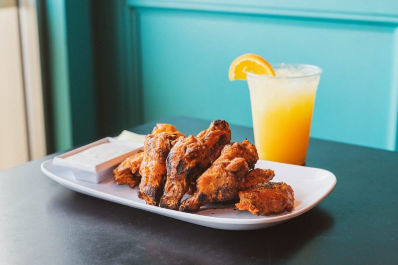 Wings and an orange cocktail at Ballyhoos, one of the best places for chicken wings in Virginia Beach
