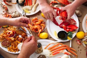 Two men enjoying a seafood feast.