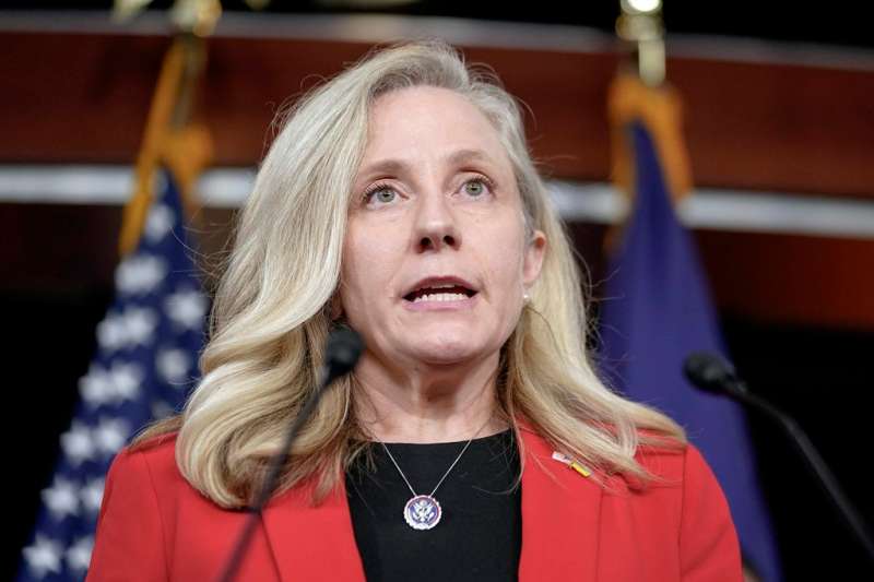 Photo of a woman politician speaking in front of an podium.