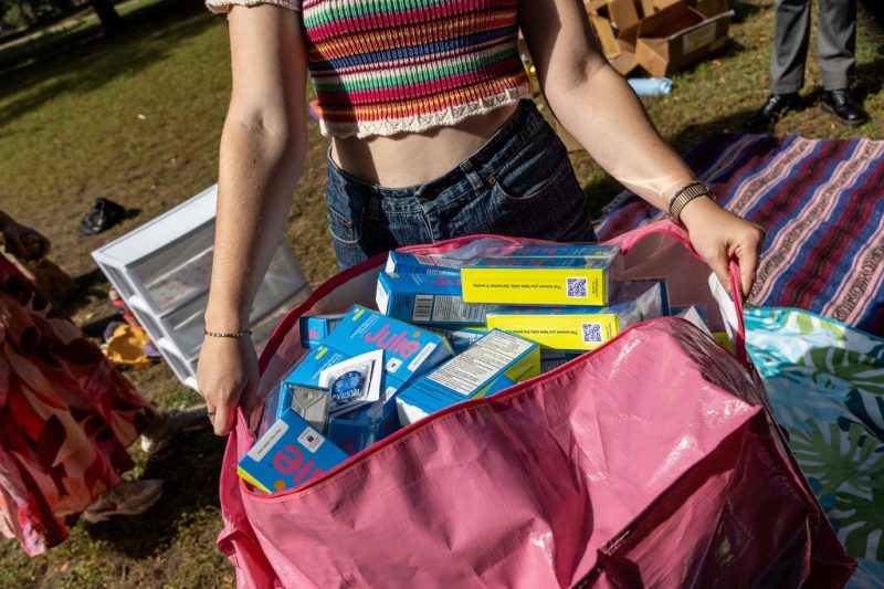 Photo of a woman holding a large ag of contraceptives.