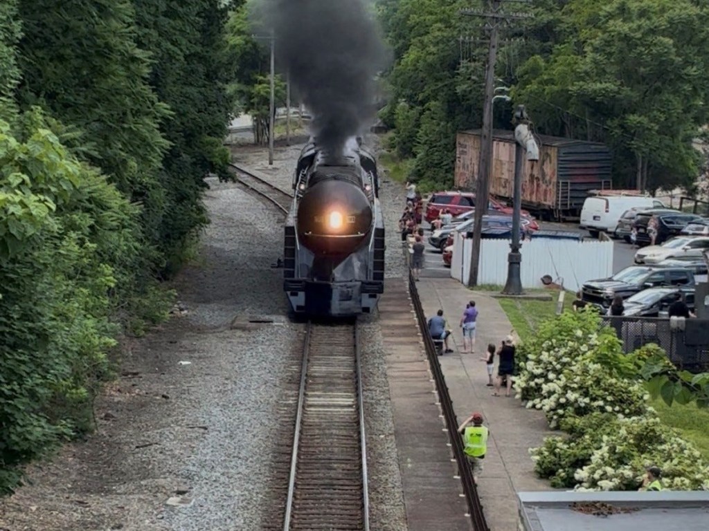 A train blows smoke as it rolls down the tracks