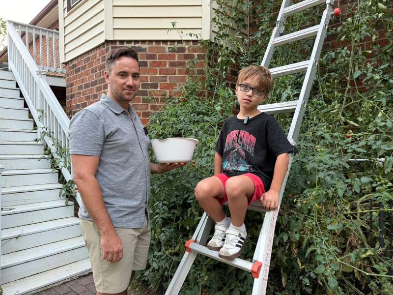 Staunton father and son stand near plant