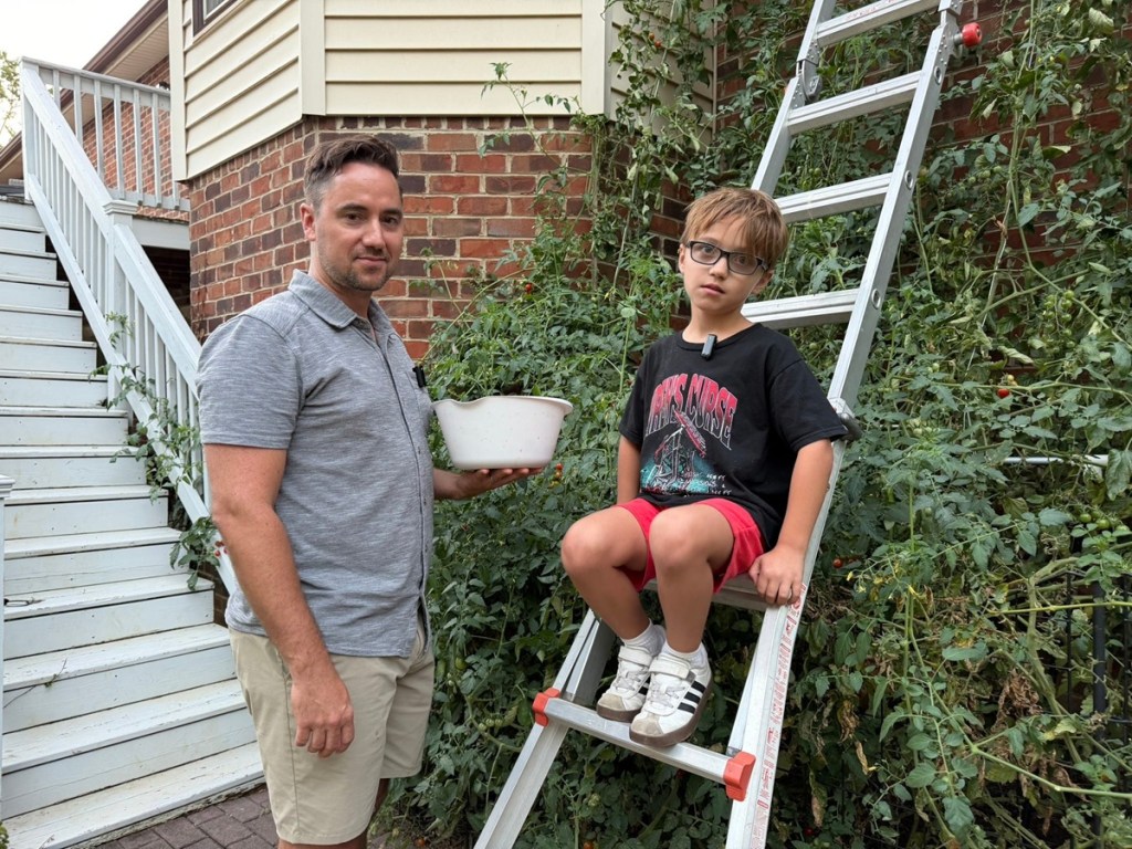 Staunton father and son stand near plant